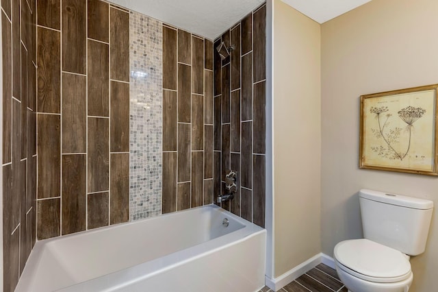 bathroom featuring tiled shower / bath combo and toilet