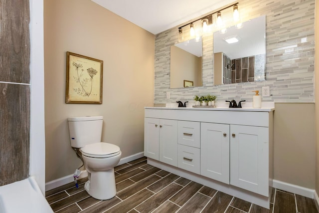 bathroom featuring tasteful backsplash, vanity, and toilet