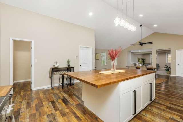 kitchen with white cabinetry, a center island, dark hardwood / wood-style flooring, wooden counters, and pendant lighting