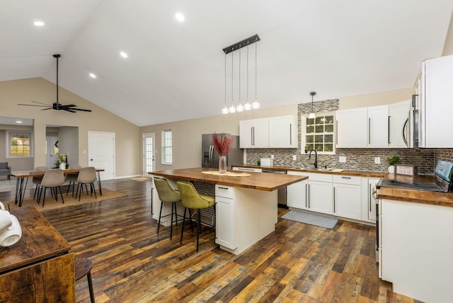 kitchen featuring wood counters, a center island, white cabinetry, and stainless steel appliances