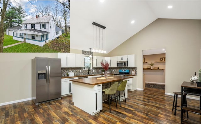 kitchen featuring butcher block counters, white cabinets, high vaulted ceiling, and appliances with stainless steel finishes