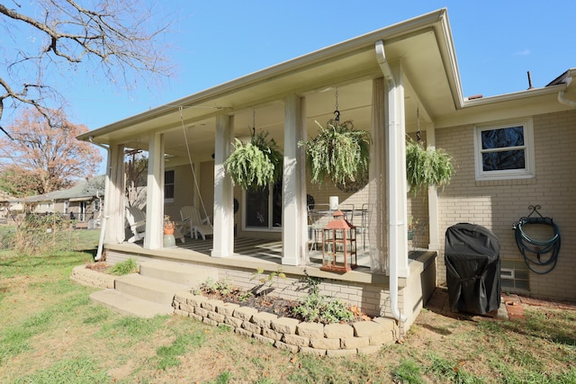 rear view of house with covered porch and a yard