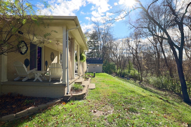 view of yard with covered porch and a storage shed