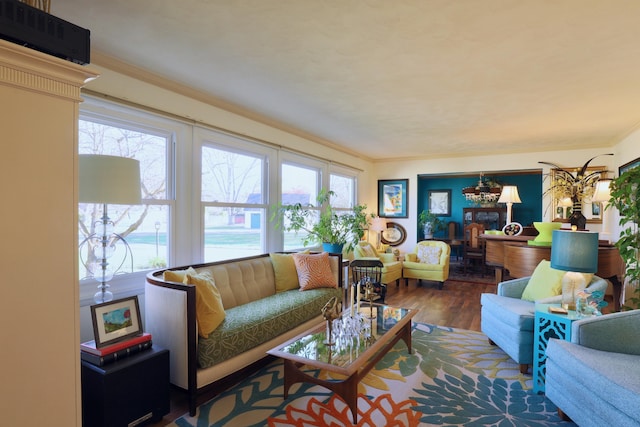 living room with crown molding, dark wood-type flooring, and an inviting chandelier