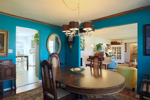 dining room with wood-type flooring, crown molding, and a chandelier