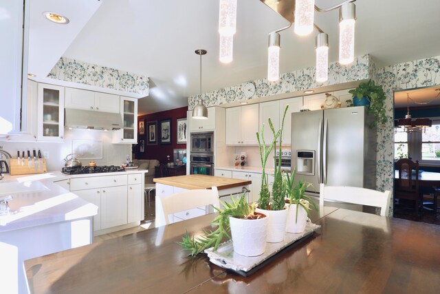 kitchen with white cabinets, appliances with stainless steel finishes, pendant lighting, and sink