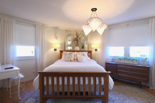 bedroom with multiple windows and dark wood-type flooring