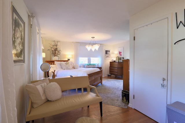 bedroom with wood-type flooring and a notable chandelier