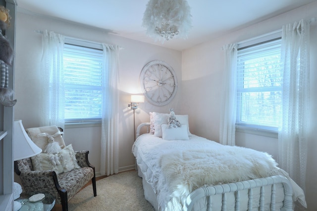 bedroom featuring light carpet and multiple windows