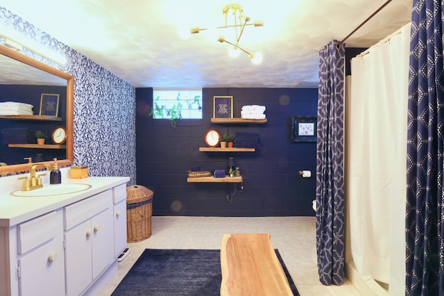 bathroom with tile patterned floors, vanity, curtained shower, and a notable chandelier