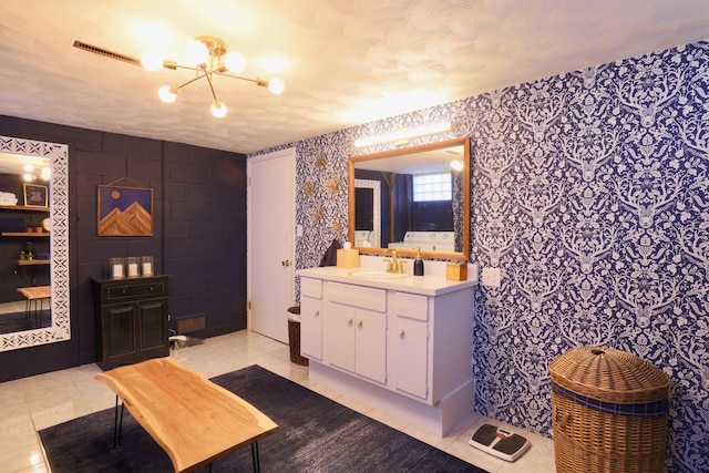 bathroom with tile patterned flooring, vanity, and an inviting chandelier