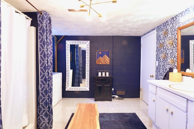 bathroom featuring tile patterned flooring, vanity, and tile walls