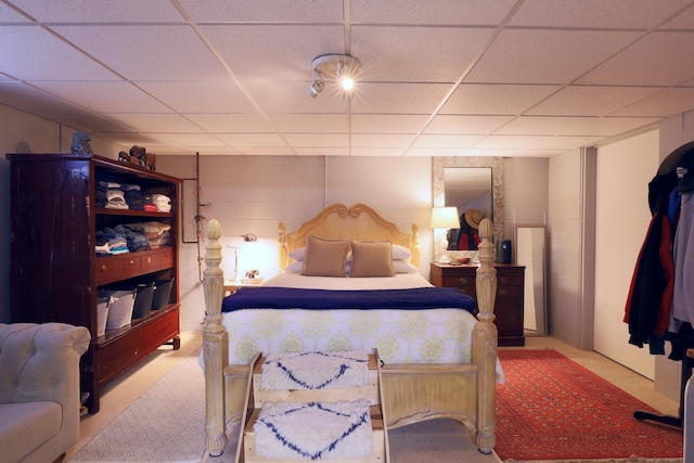 carpeted bedroom featuring a drop ceiling