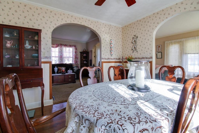 carpeted dining room with ceiling fan and ornamental molding