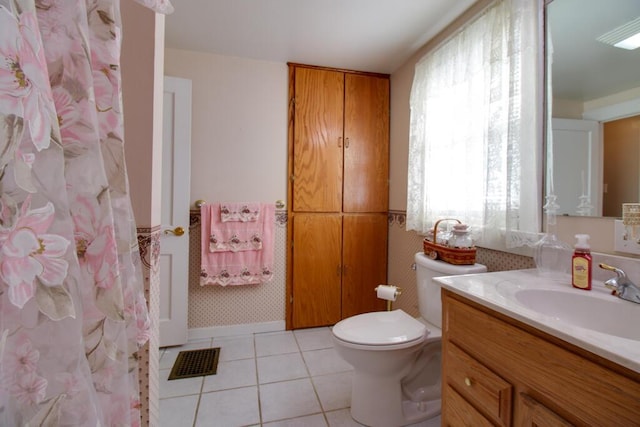 bathroom featuring toilet, vanity, tile patterned floors, and a wealth of natural light