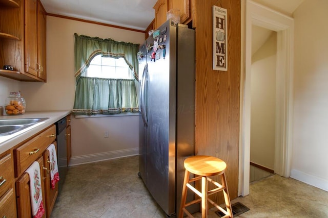 kitchen featuring sink, crown molding, and stainless steel appliances