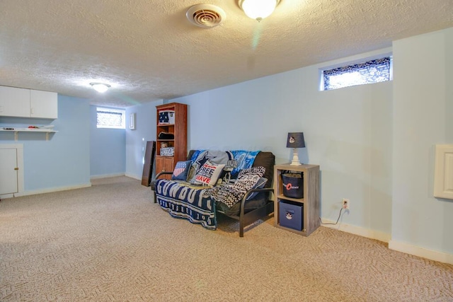 sitting room featuring light carpet and a textured ceiling