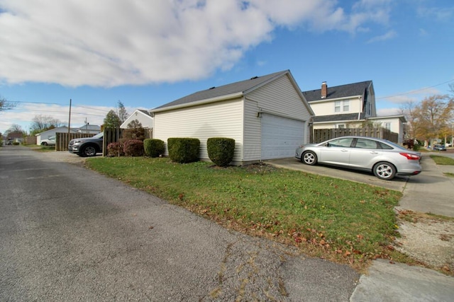 view of side of home featuring a lawn and a garage