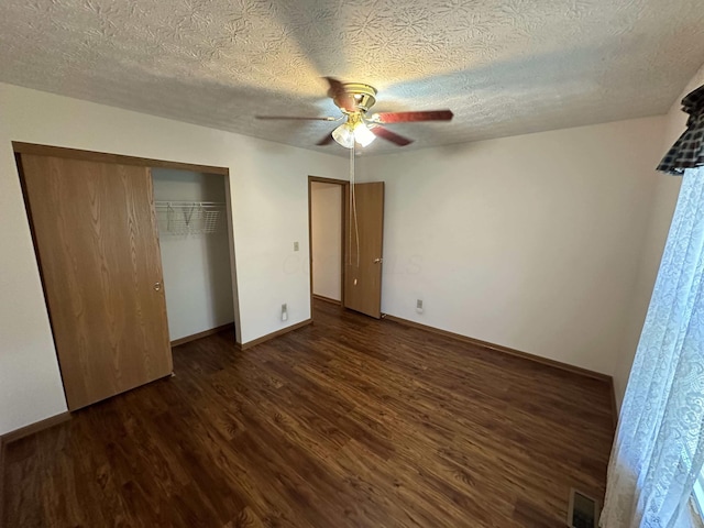 unfurnished bedroom featuring dark hardwood / wood-style floors, ceiling fan, a textured ceiling, and a closet