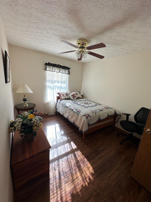 bedroom featuring ceiling fan, dark hardwood / wood-style floors, and a textured ceiling