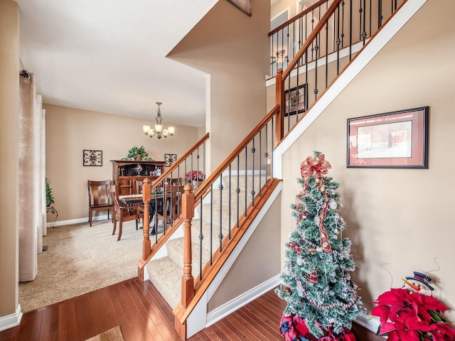 staircase featuring a notable chandelier and wood-type flooring