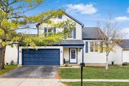 front of property with a front lawn and a garage