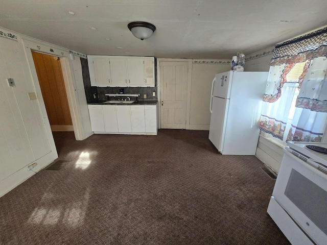 kitchen with white cabinetry, sink, dark colored carpet, tasteful backsplash, and white appliances