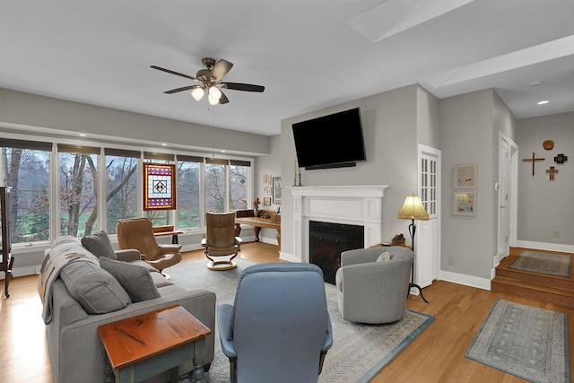 living room with ceiling fan and light hardwood / wood-style flooring