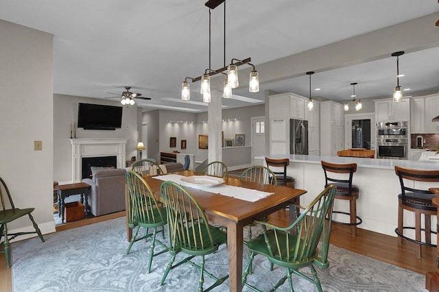 dining area with ceiling fan and light wood-type flooring