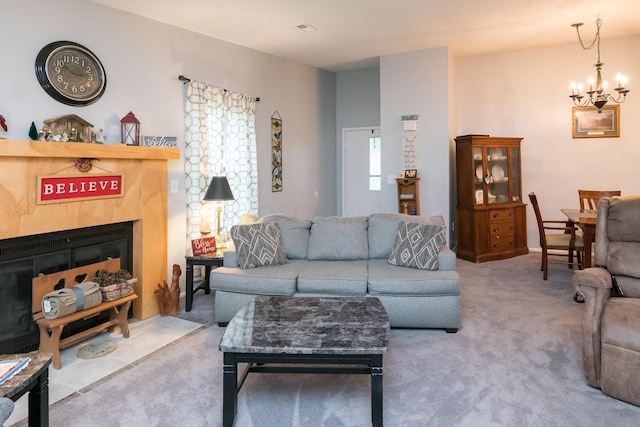 living room with a chandelier, carpet, and a fireplace