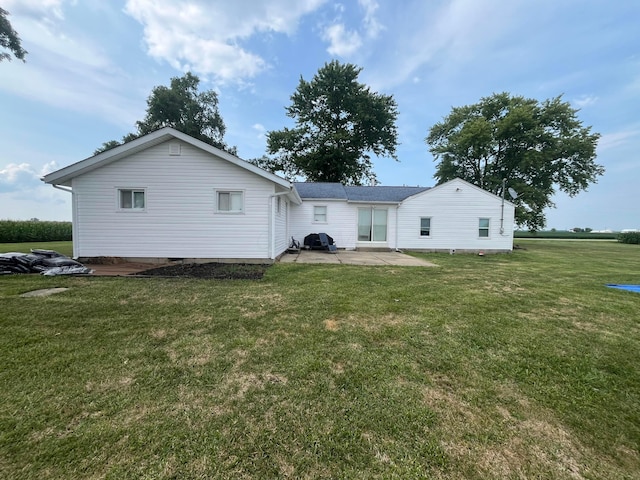 back of property featuring a patio and a lawn