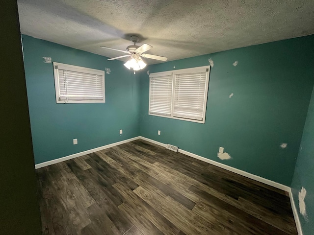 empty room featuring ceiling fan, dark hardwood / wood-style flooring, and a textured ceiling