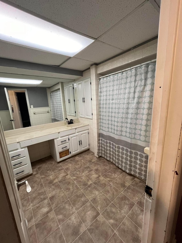 bathroom featuring tile patterned flooring, a shower with curtain, vanity, and a drop ceiling