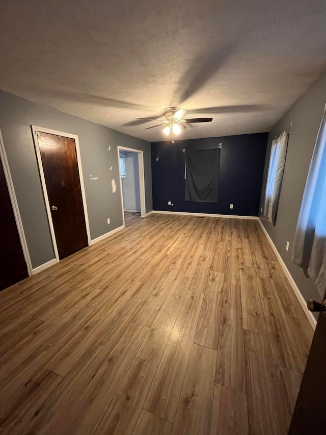 empty room with hardwood / wood-style floors and ceiling fan