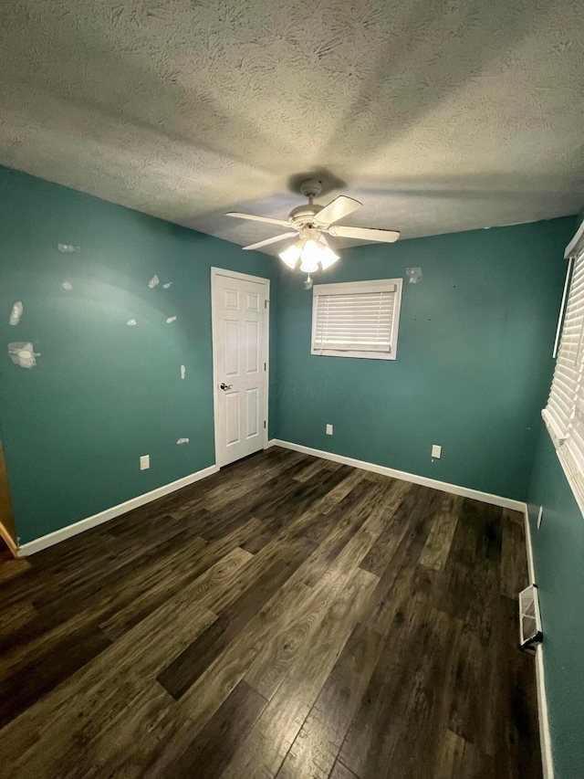 unfurnished bedroom featuring a textured ceiling, dark hardwood / wood-style flooring, and ceiling fan