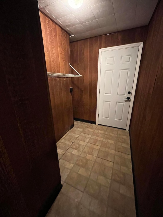 laundry area with hookup for an electric dryer and wooden walls