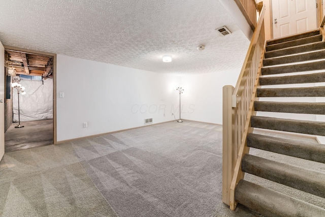 basement with carpet and a textured ceiling