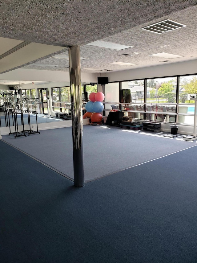 exercise room featuring carpet and a textured ceiling