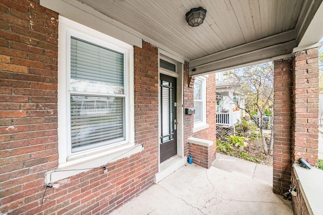 view of exterior entry featuring covered porch