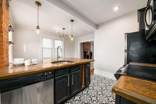 kitchen featuring black appliances, wood counters, sink, and hanging light fixtures