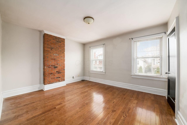 unfurnished room with hardwood / wood-style flooring and plenty of natural light