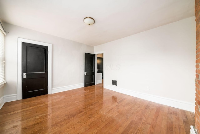 unfurnished room with hardwood / wood-style flooring