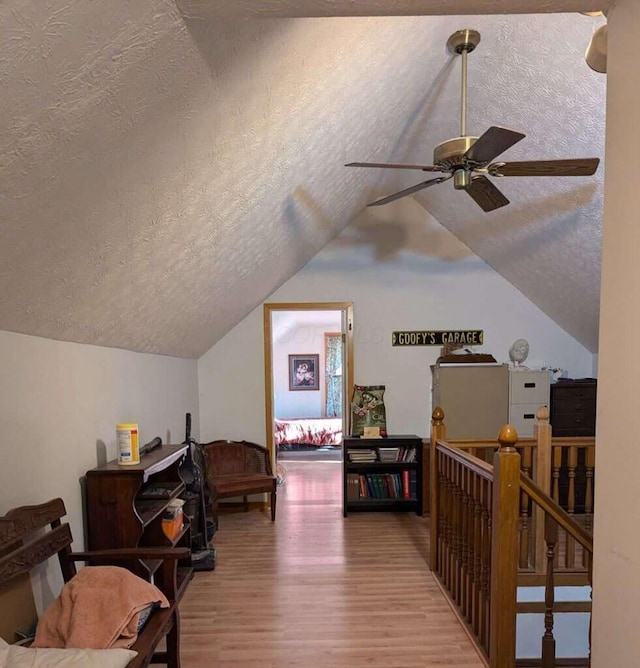 interior space featuring a textured ceiling, lofted ceiling, and hardwood / wood-style flooring