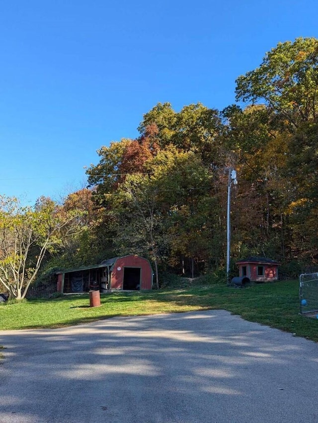 view of front of house featuring a front lawn and an outdoor structure