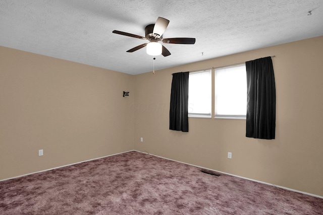 carpeted empty room featuring ceiling fan and a textured ceiling