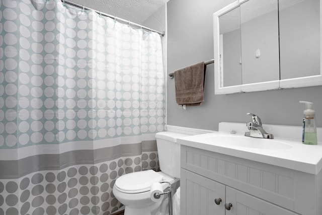 bathroom with vanity, toilet, and a textured ceiling