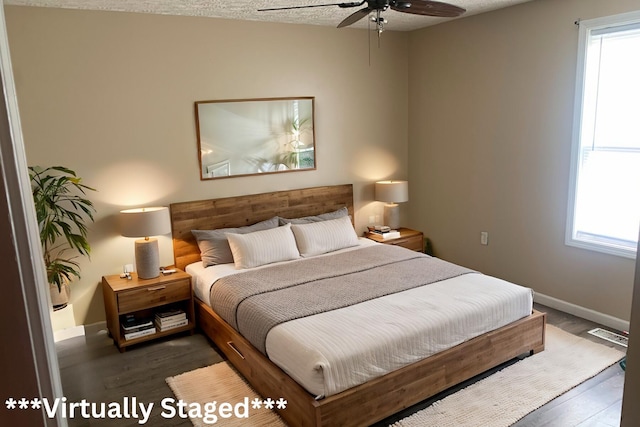 bedroom with dark hardwood / wood-style floors, ceiling fan, and a textured ceiling