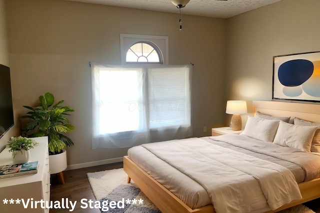 bedroom with dark wood-type flooring and a textured ceiling