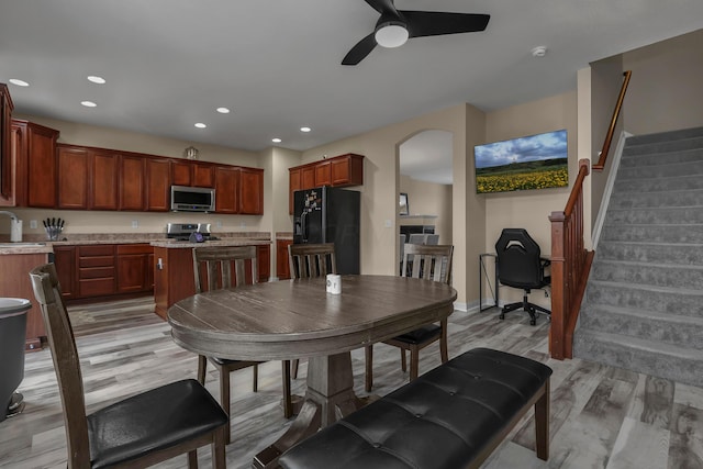 dining space featuring ceiling fan, sink, and light hardwood / wood-style flooring