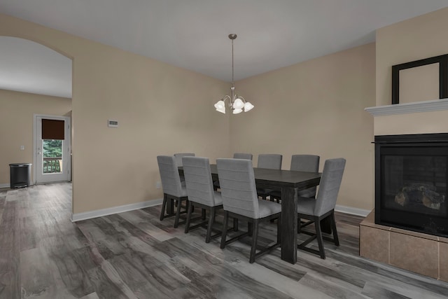 dining space with wood-type flooring and an inviting chandelier